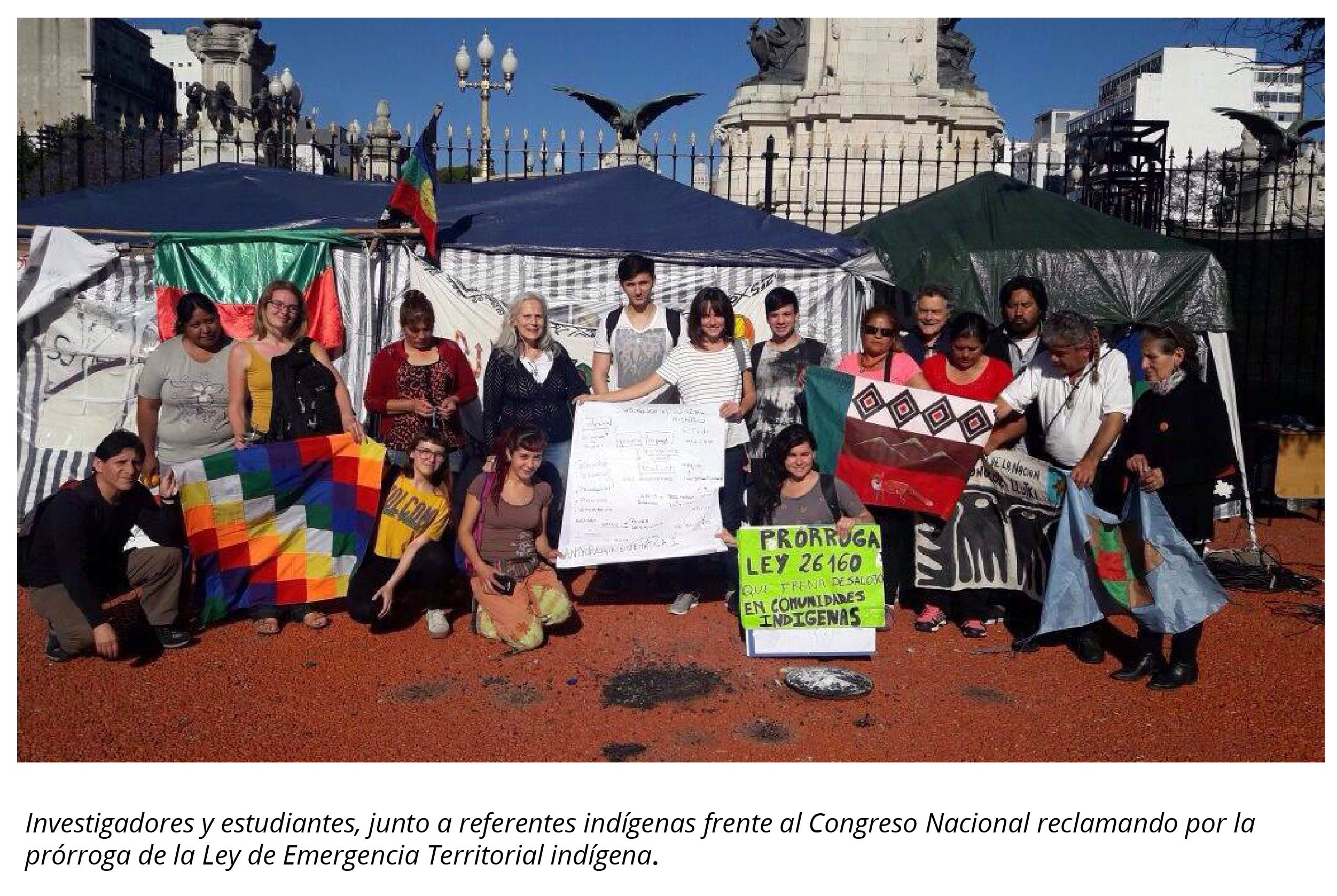 La imagen muestra investigadores y estudiantes junto a referentes indígenas frente al Consejo Nacional reclamando por la prórroga de la Ley de Emergencia Territorial indígena.