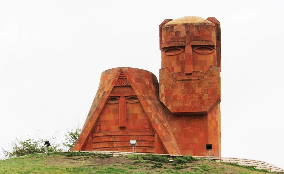 La imagen muestra el monumento Somos Nuestras Montañas, también llamado Tatik Papik, ubicado al norte de Stepanakert,​ la ciudad capital de la autoproclamada República de Nagorno Karabaj.