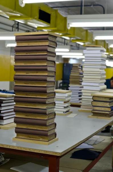 La imagen muestra una pila de libros con nueva encuadernación, ya terminados.