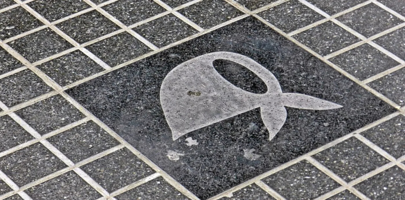 La imagen muestra un pañuelo de Abuelas de Plaza de Mayo pintado sobre baldosas.